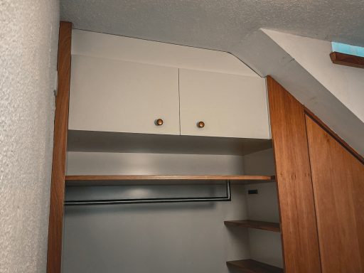 Gaderobenlösung in Eiche und weiß lackiertem Mdf. Blick auf die oberen Staufächer.