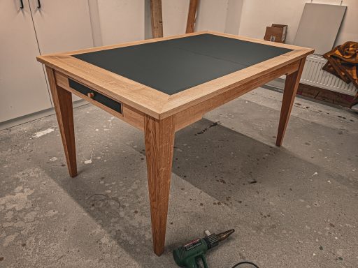 Ausziehbarer Esstisch in Eiche und schwarzem Linoleum.