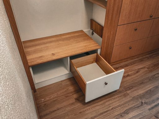 Gaderobenlösung in Eiche und weiß lackiertem Mdf. Blick auf des Unteren Teil mit geöffneter Schublade